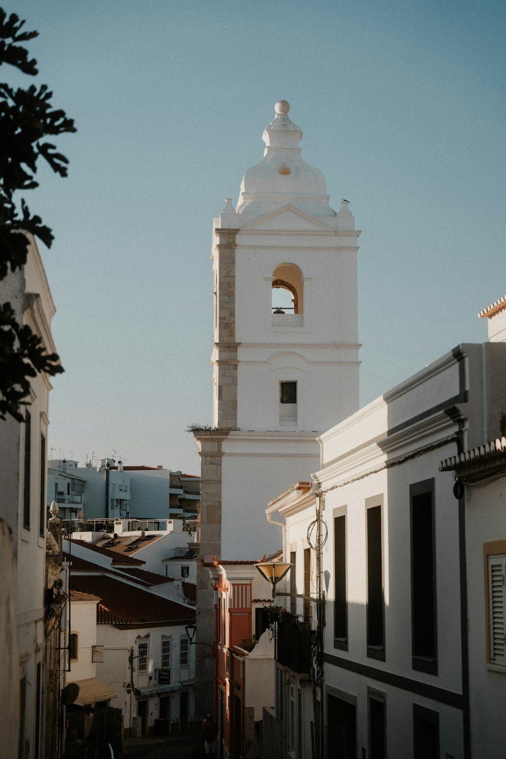 a tall white clock tower towering over a city