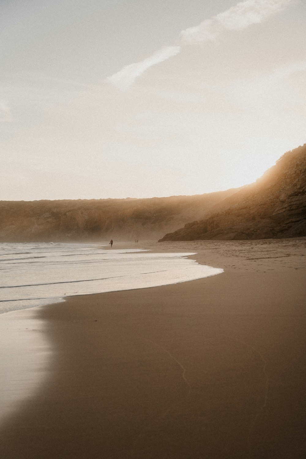 a person walking on a beach near the ocean