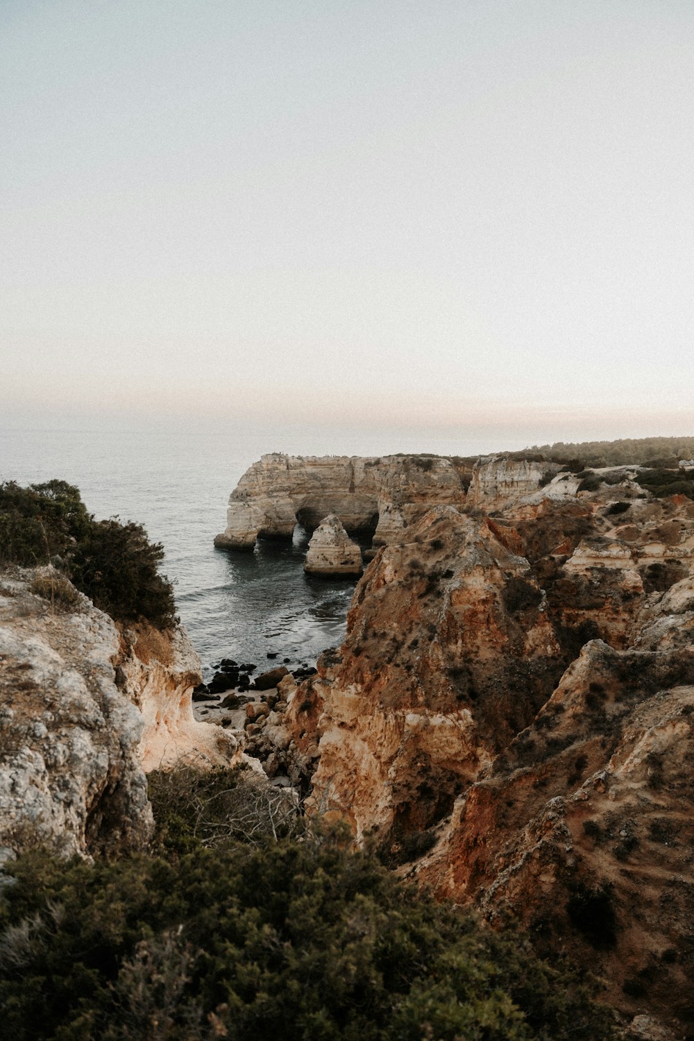 a person standing on top of a cliff near the ocean
