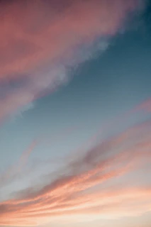 Soft pastel clouds reflecting on a still waterhole as the day fades into night.