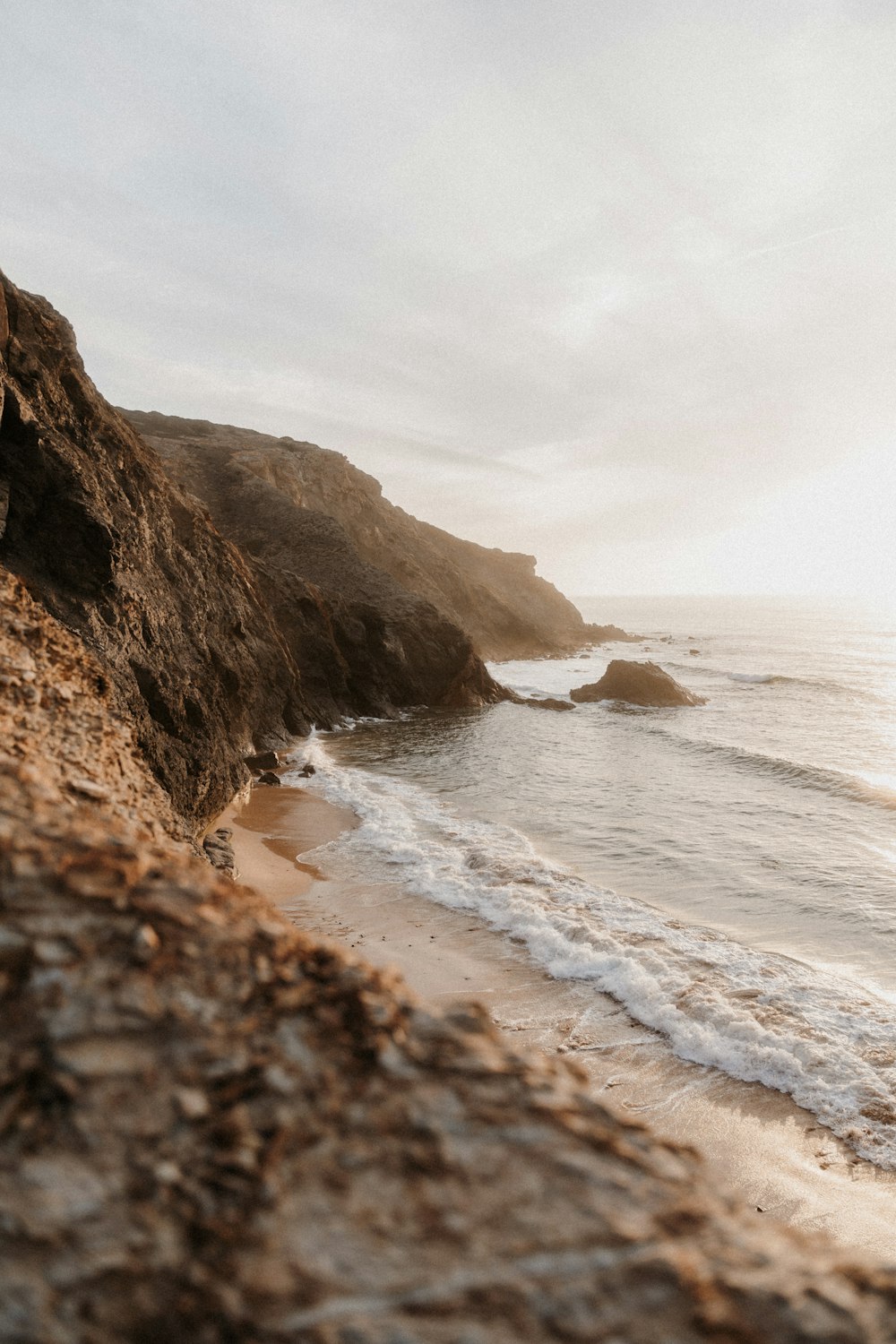 a person standing on a beach next to the ocean