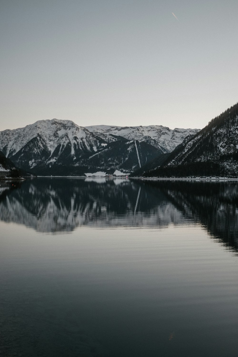 a lake surrounded by snow covered mountains