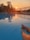 Relaxed man dipping feet in a calm hotel swimming pool at sunset