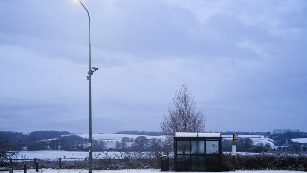 a bus stop sitting on the side of a road covered in snow