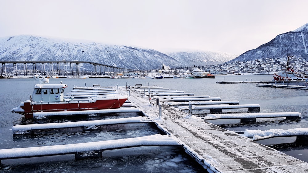 a red and white boat is docked at a pier