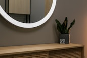 A smart LED mirror illuminating a stylish bathroom setting.