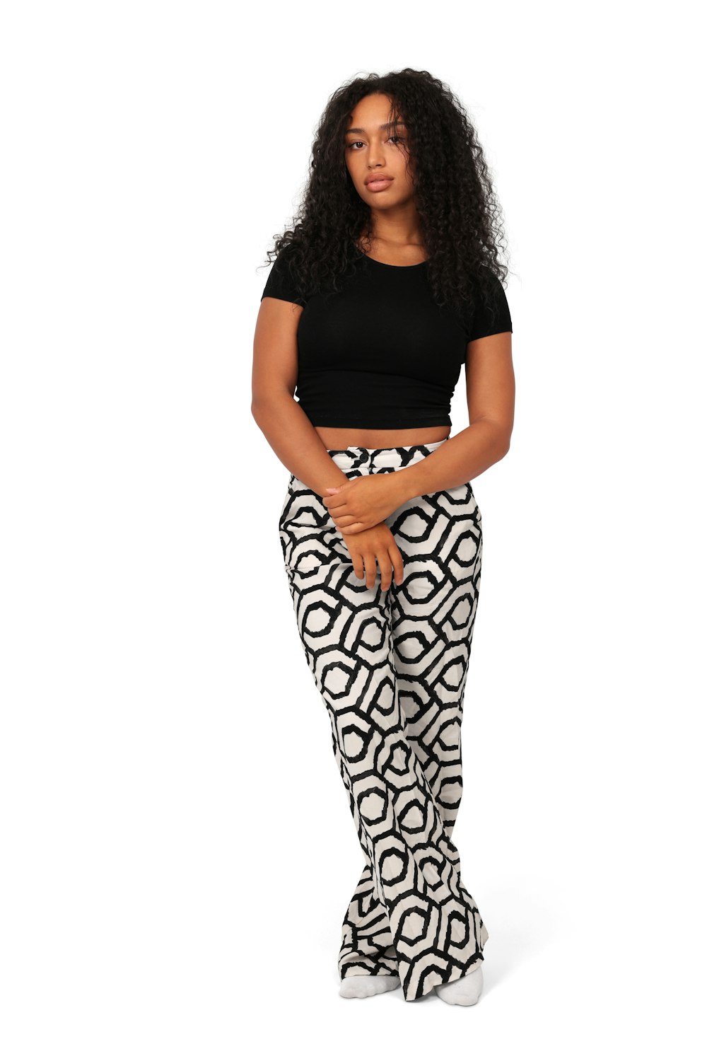 a woman in a black top and patterned pants