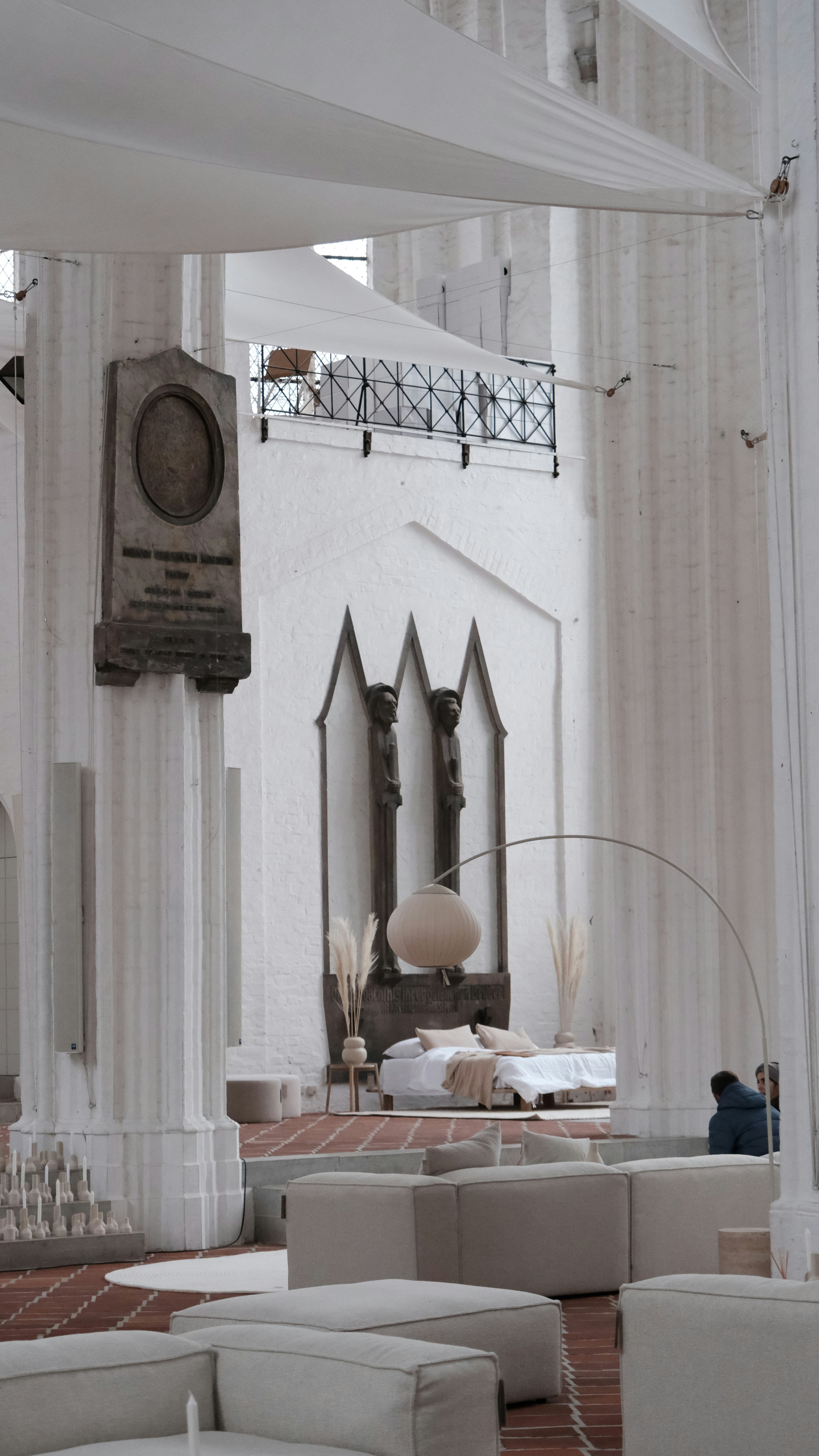 a living room with white couches and a clock on the wall
