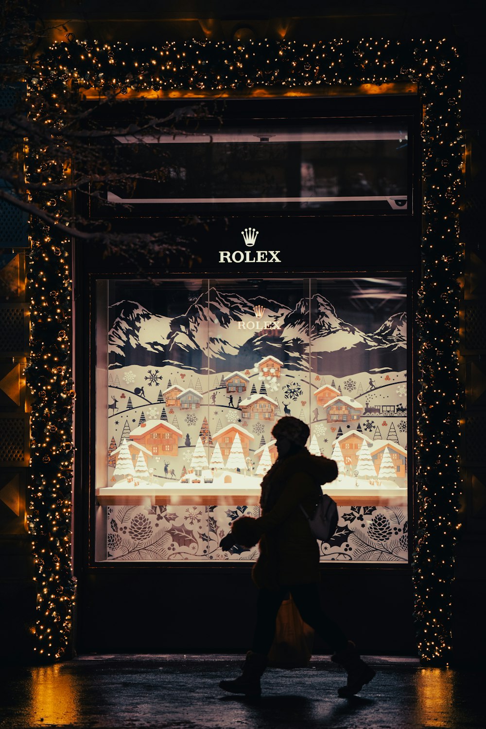 a person walking in front of a store with christmas lights
