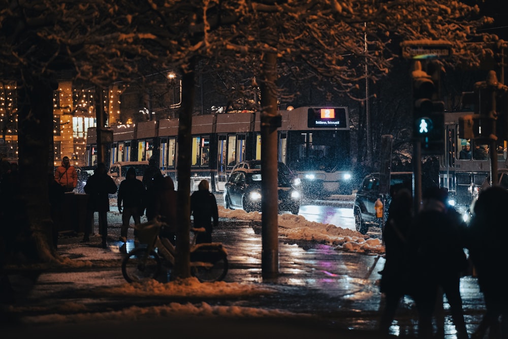 a group of people walking down a street at night