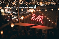 A lively outdoor ice bar with colorful lights and skiers mingling after a day on the slopes.