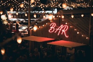 A lively outdoor ice bar with colorful lights and skiers mingling after a day on the slopes.
