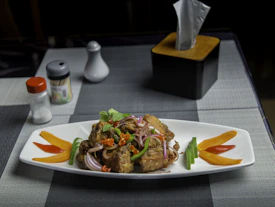 a white plate topped with meat and veggies