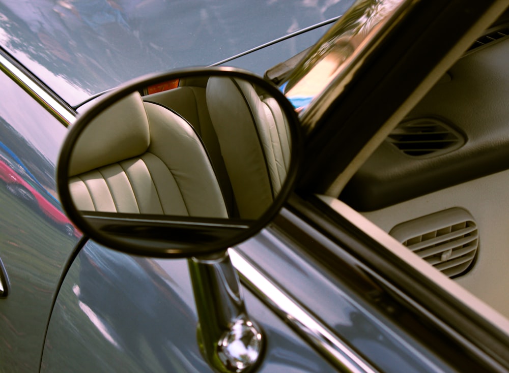 a car's side view mirror reflecting the interior of a car