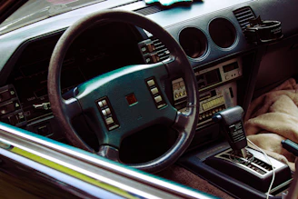 Close-up of a vintage car dashboard with colorful retro dials and a glowing cassette player.