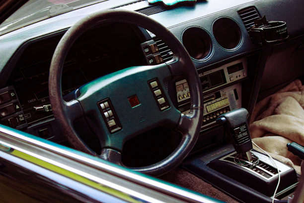 Close-up of a vintage car dashboard with colorful retro dials and a glowing cassette player.