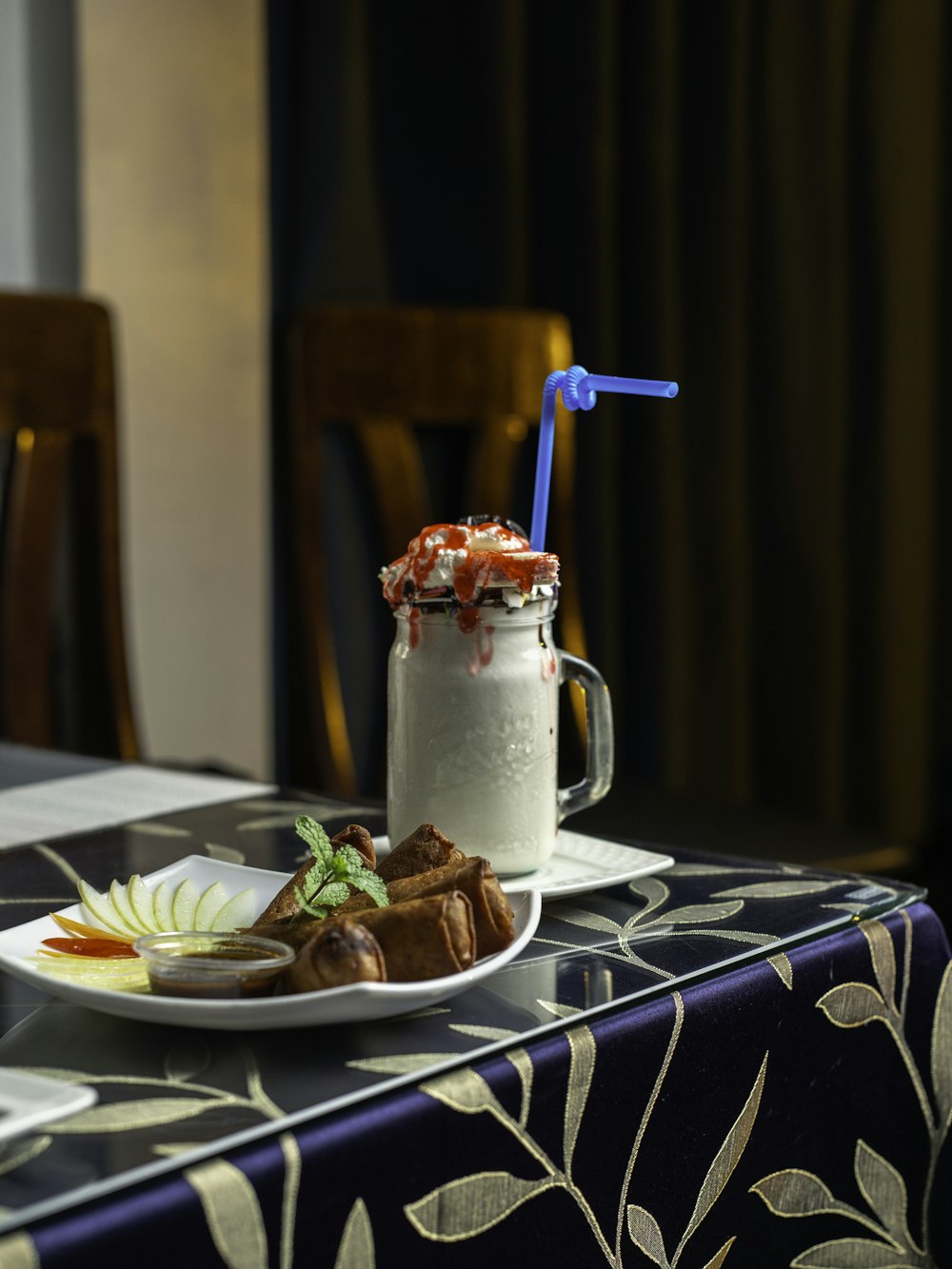 a table topped with a plate of food and a drink