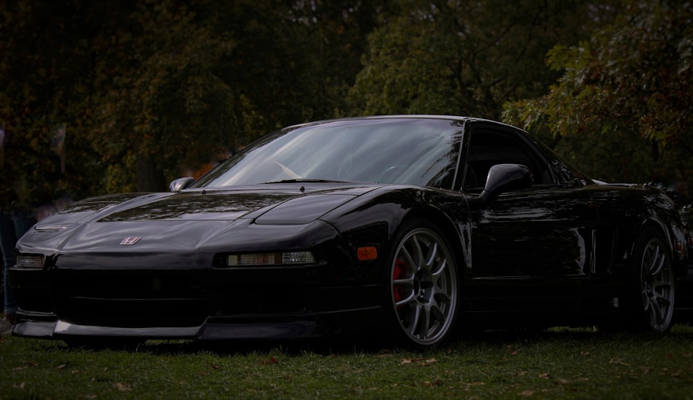 a black sports car parked in the grass