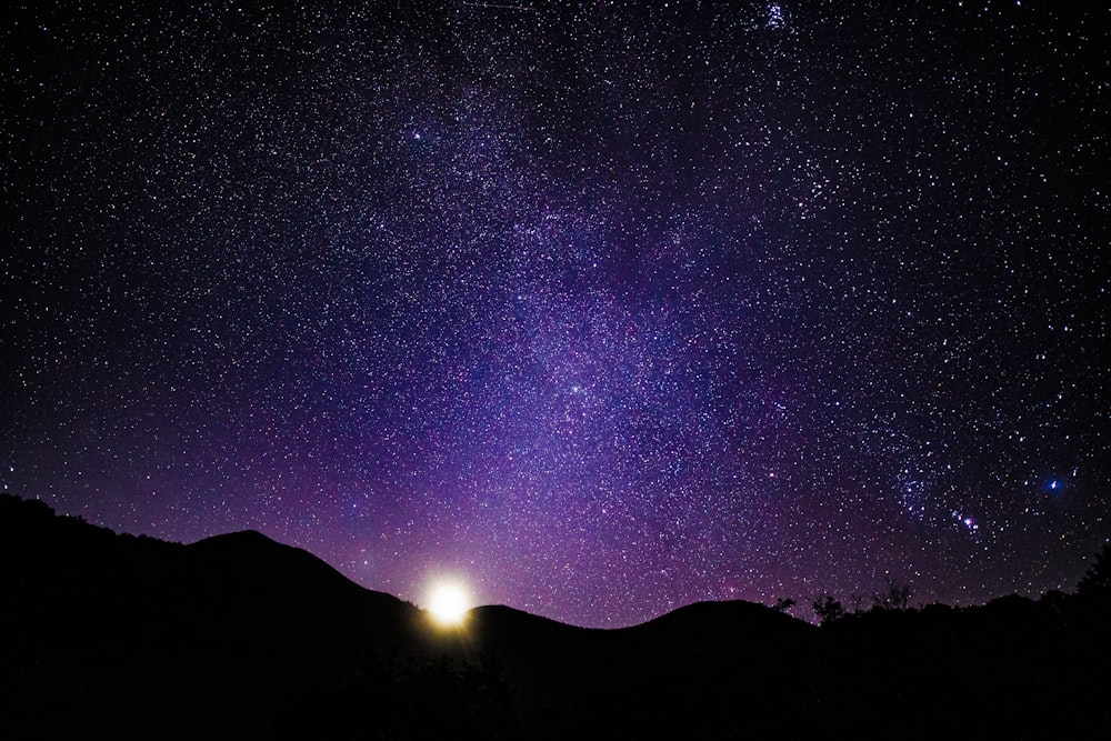 el cielo nocturno con una luz brillante en el medio