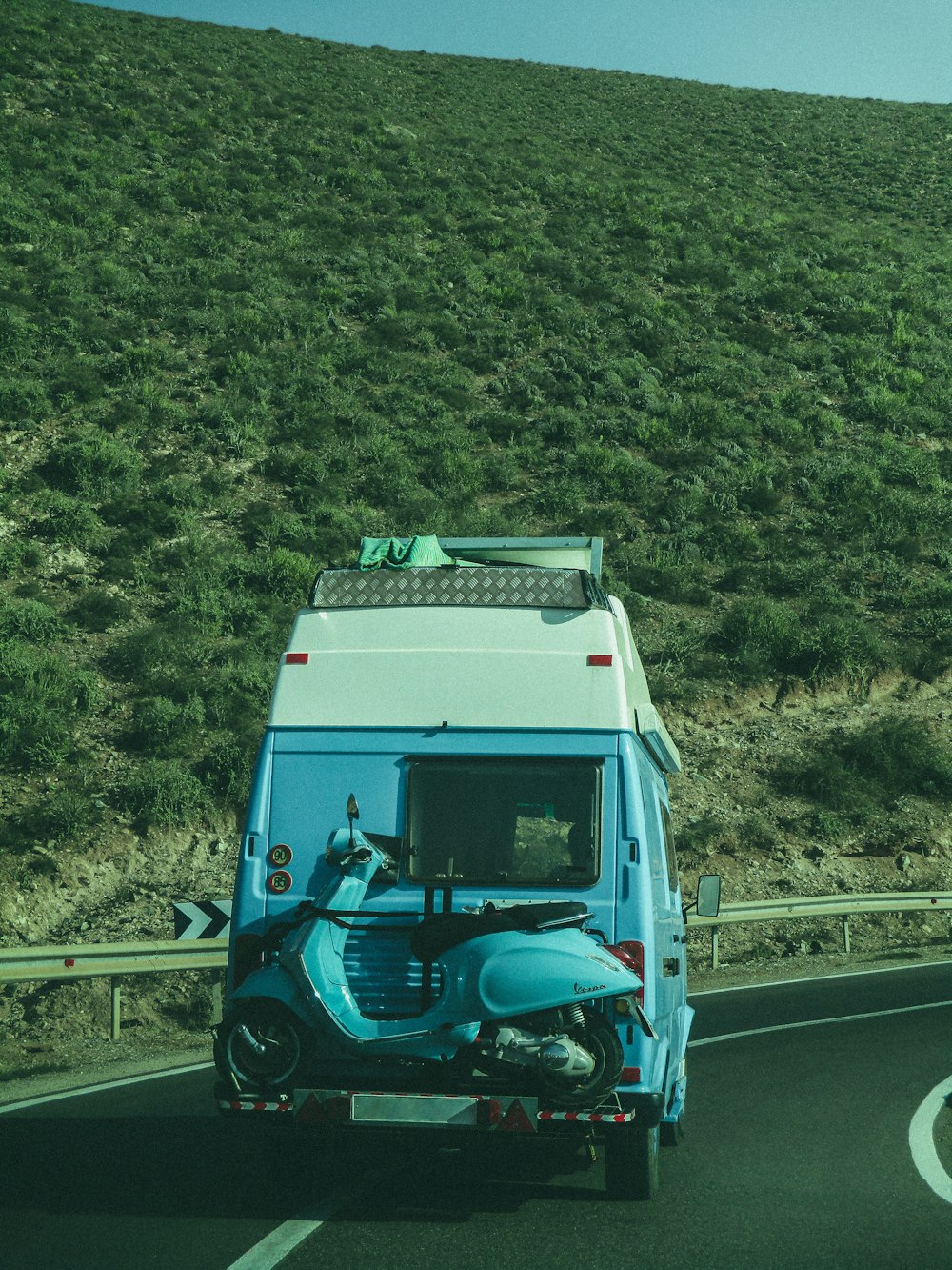 um caminhão azul e branco dirigindo por uma estrada