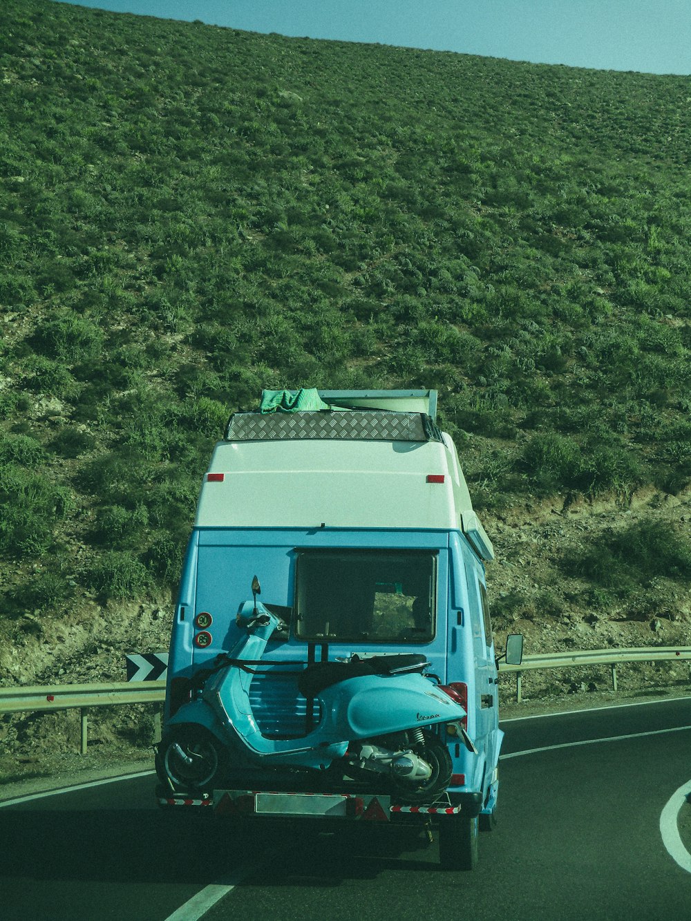 a blue and white truck driving down a road