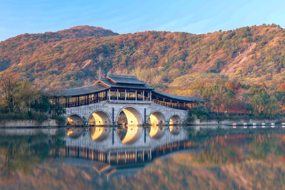 a bridge over a body of water with a mountain in the background