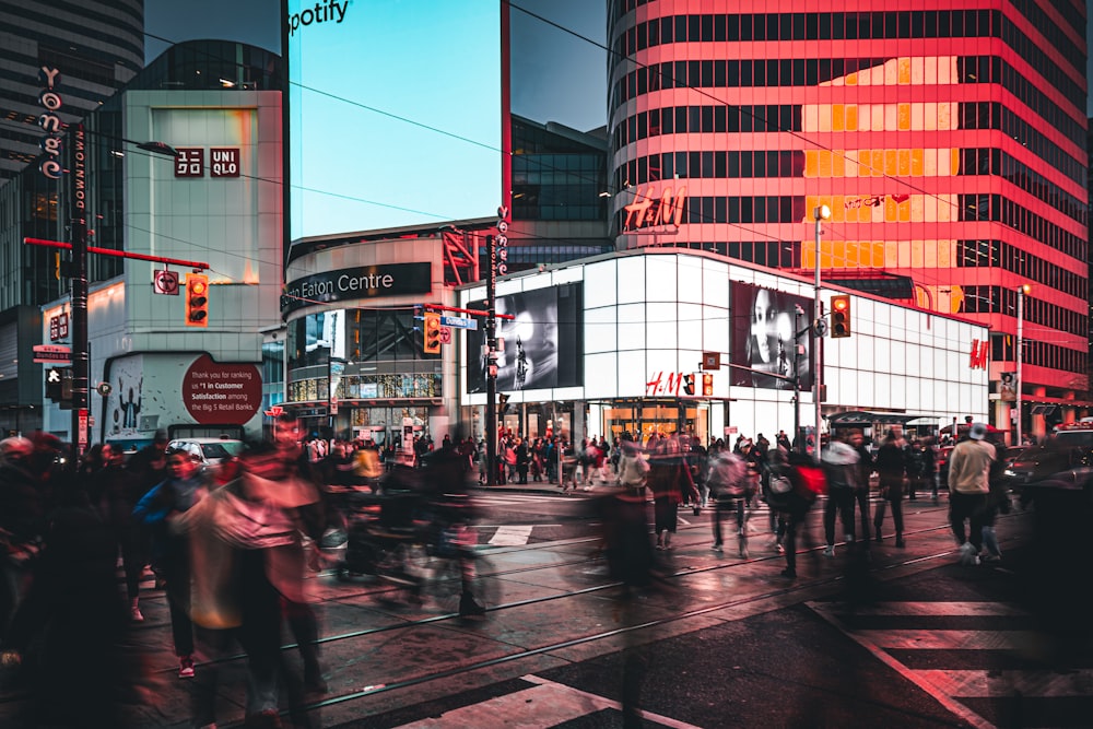 a crowd of people crossing a street at night