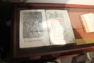 A display of several museum-style framed manuscript replicas arranged on a wooden table.