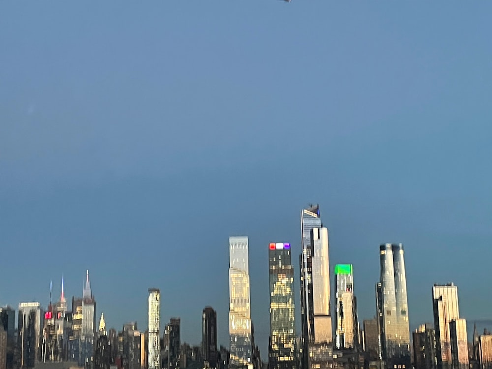 a plane flying over a large city with tall buildings