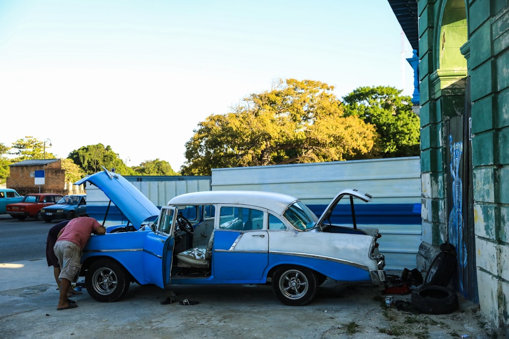 a man working on a broken down car