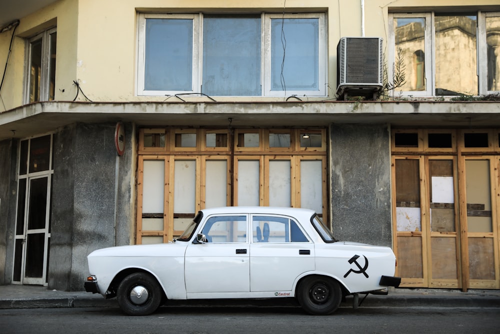 a white car parked in front of a building