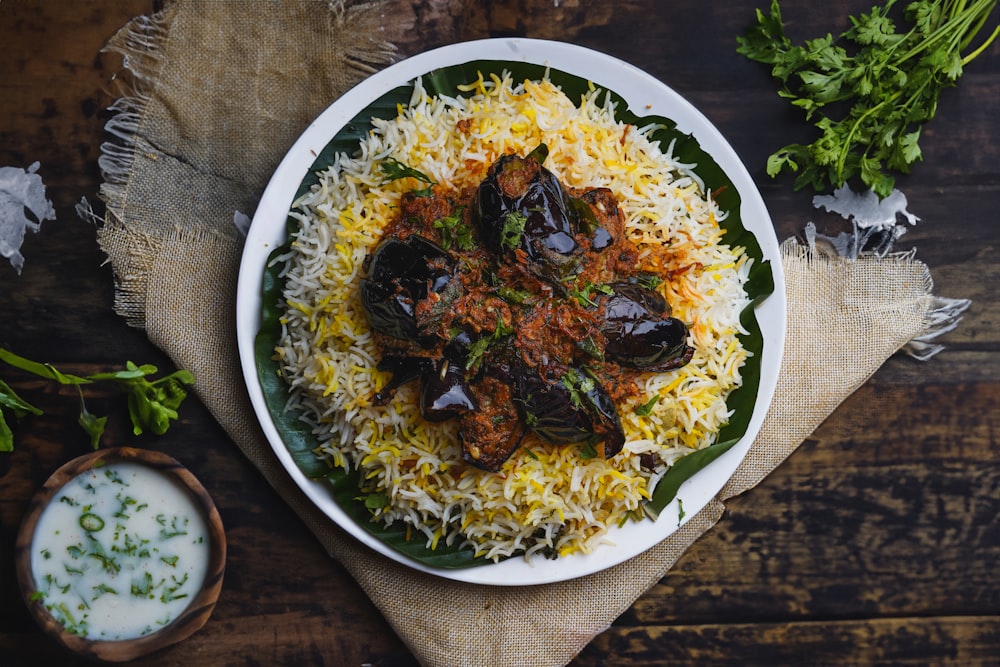 a plate of rice with mussels and sauce