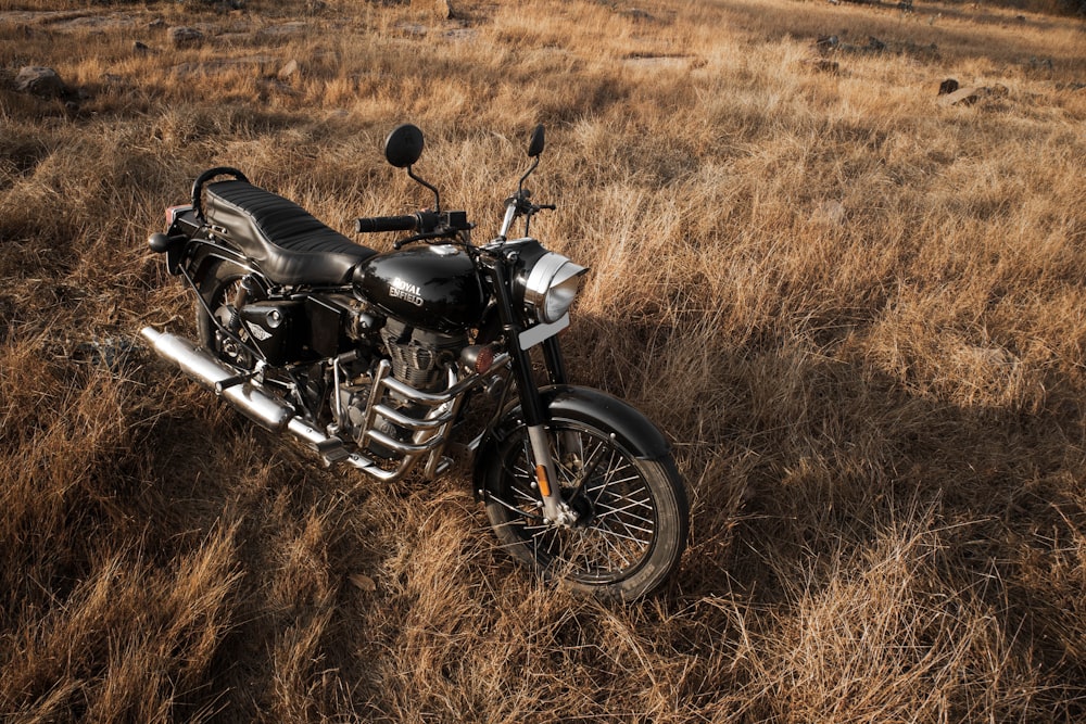a motorcycle parked in a field of dry grass