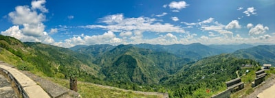 A panoramic view of lush green hills and winding trails in Himachal.