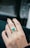 Close-up of a hand wearing a sparkling 18k gold ring with a vivid Colombian emerald.