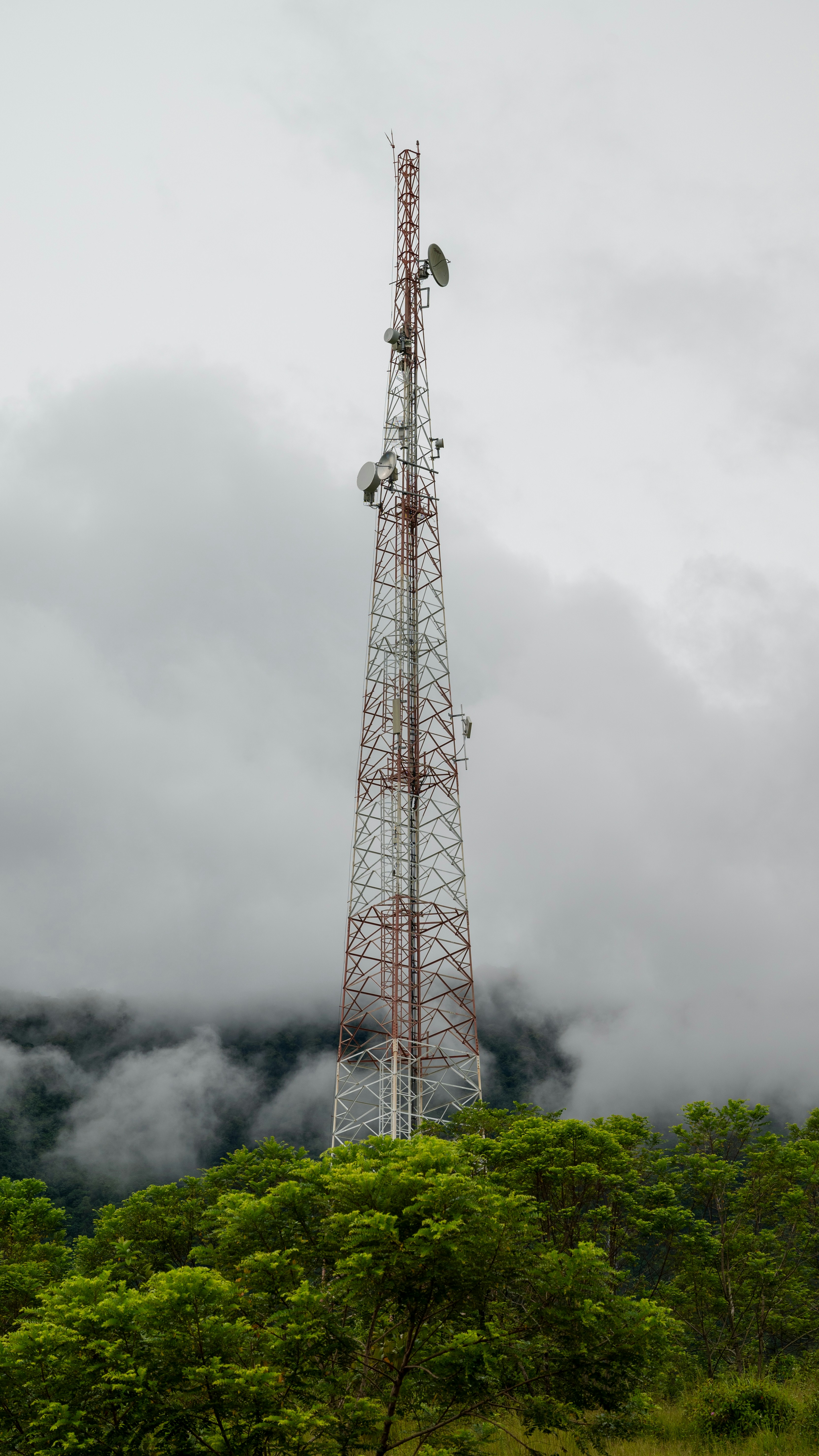 a tall tower sitting on top of a lush green hillside