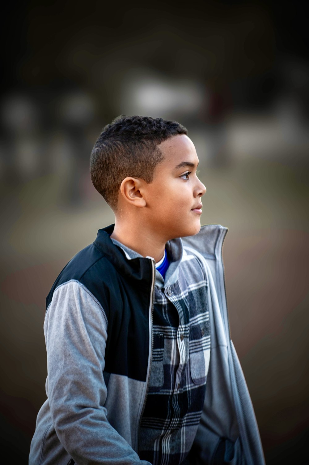 a young boy in a black and grey jacket