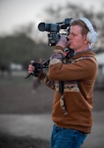a man wearing headphones and holding a camera