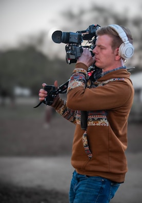 a man wearing headphones and holding a camera
