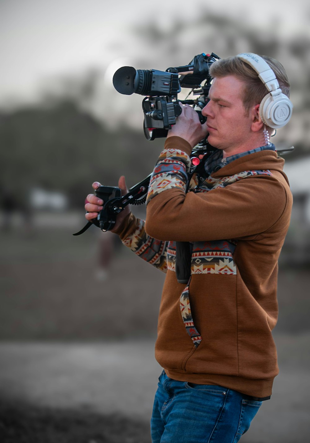 a man wearing headphones and holding a camera