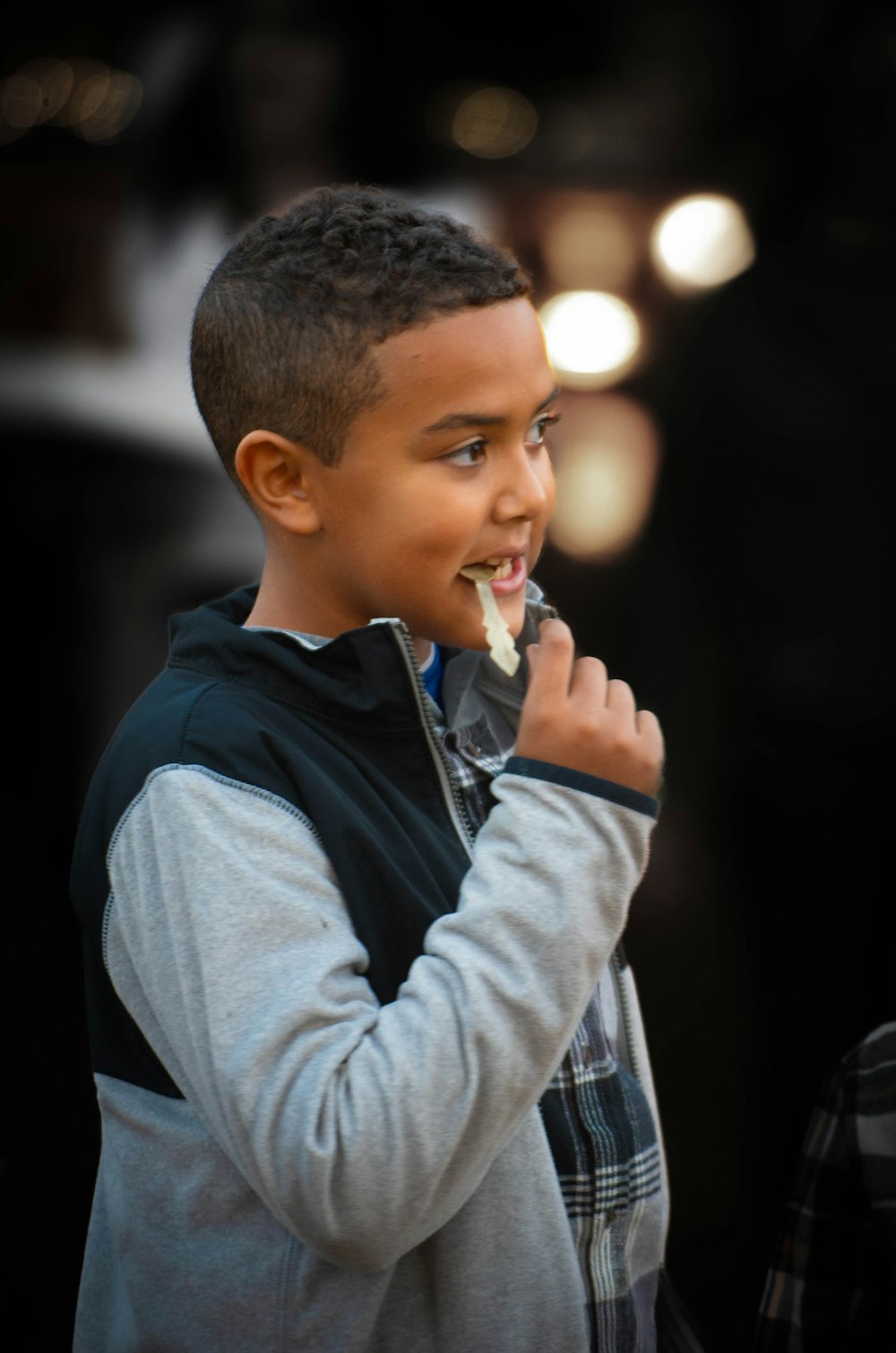 a young boy eating something with his hands