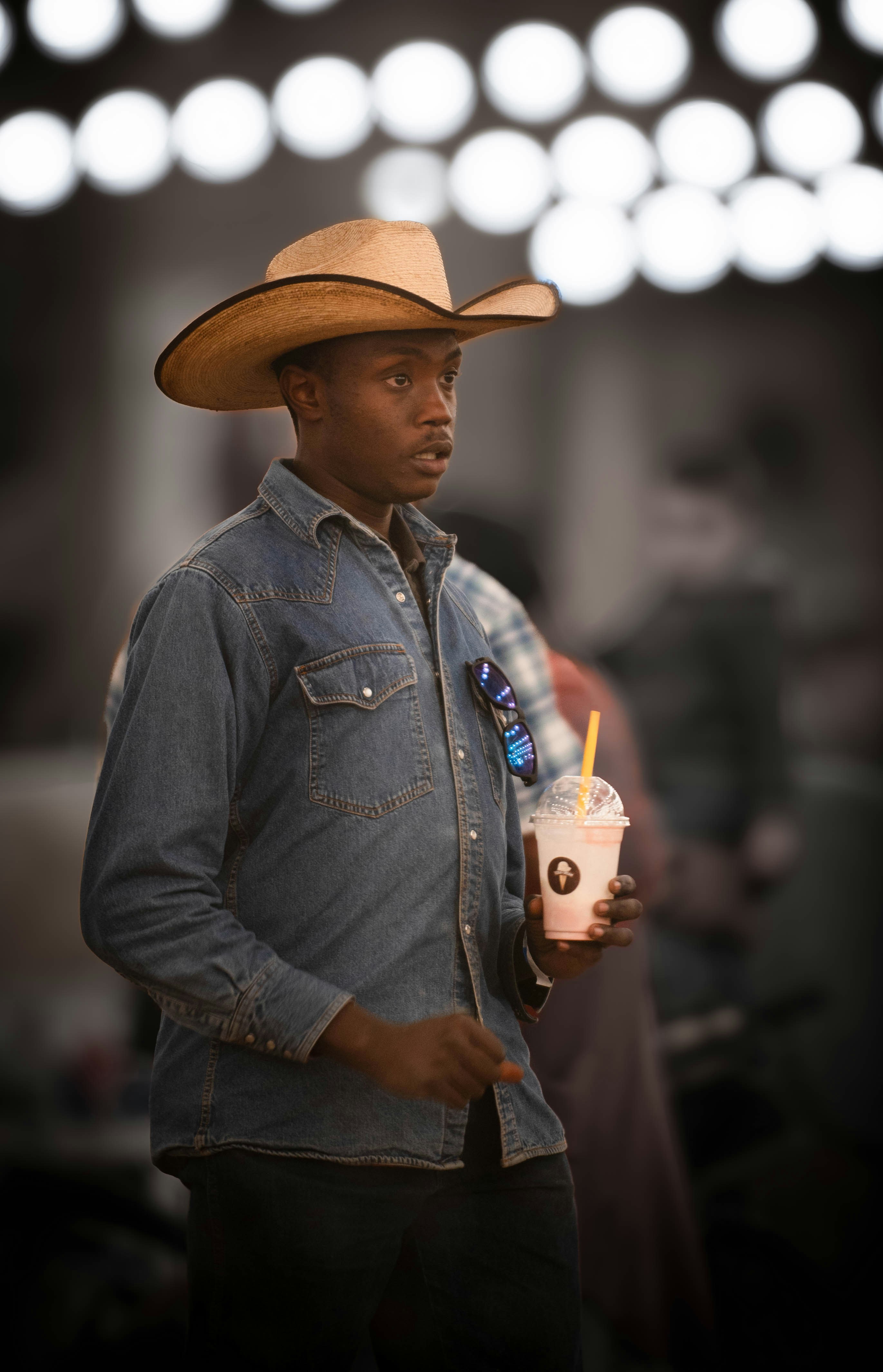 Un hombre con un sombrero de vaquero sosteniendo una bebida
