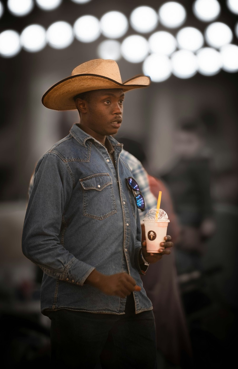 a man in a cowboy hat holding a drink