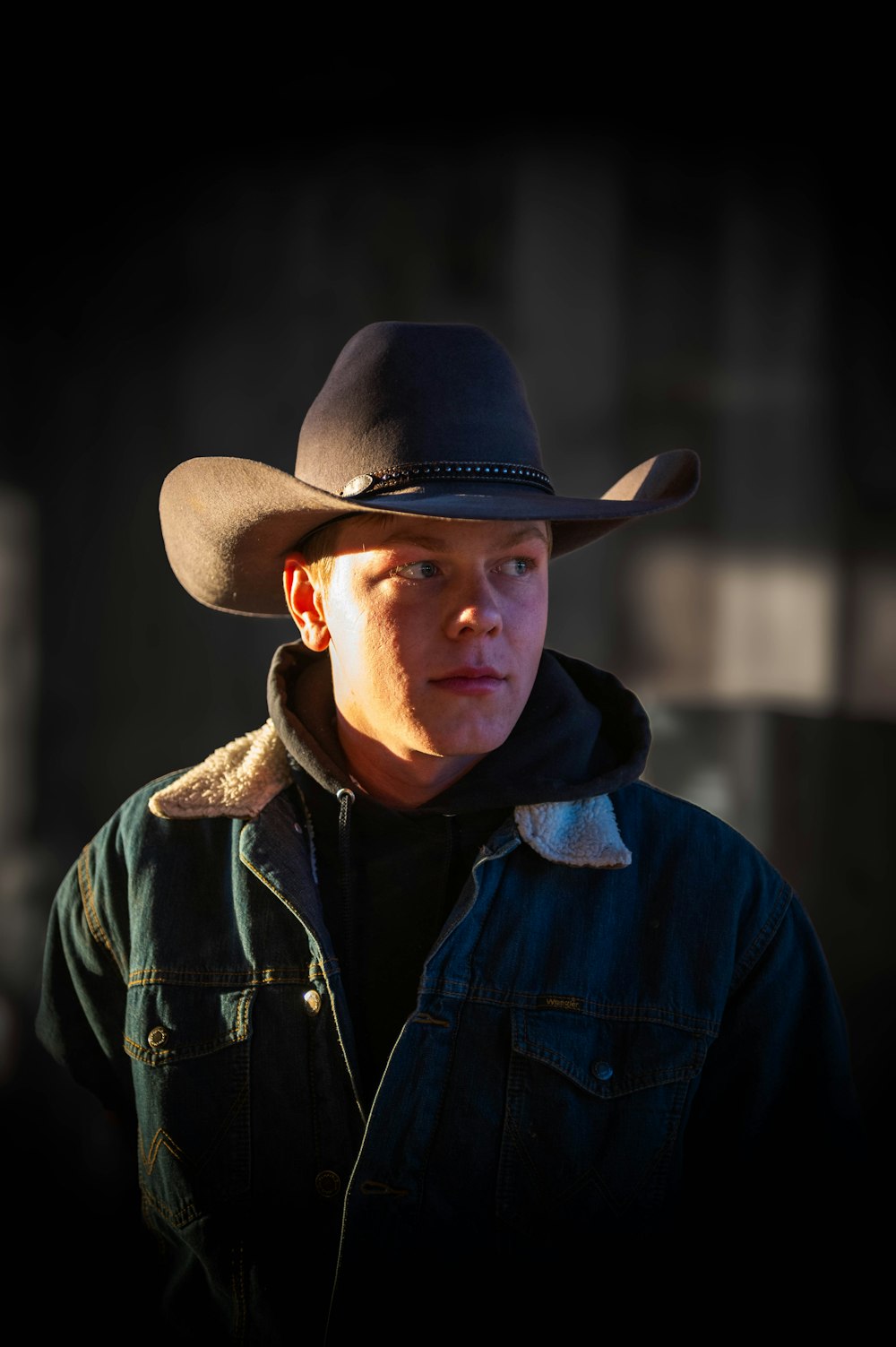a man wearing a cowboy hat in the dark