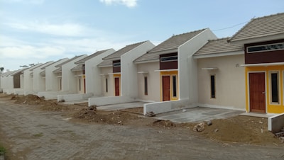 a row of houses sitting on top of a dirt road