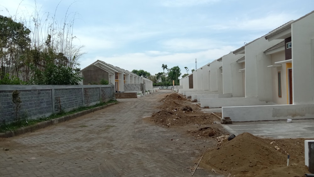 a row of houses sitting next to each other on a dirt road