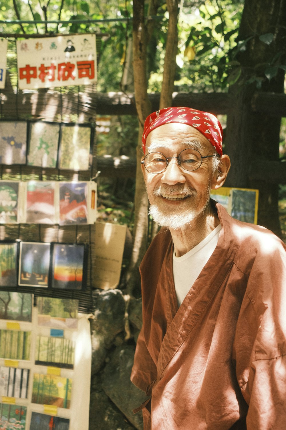 a man with a red bandanna standing in front of a tree