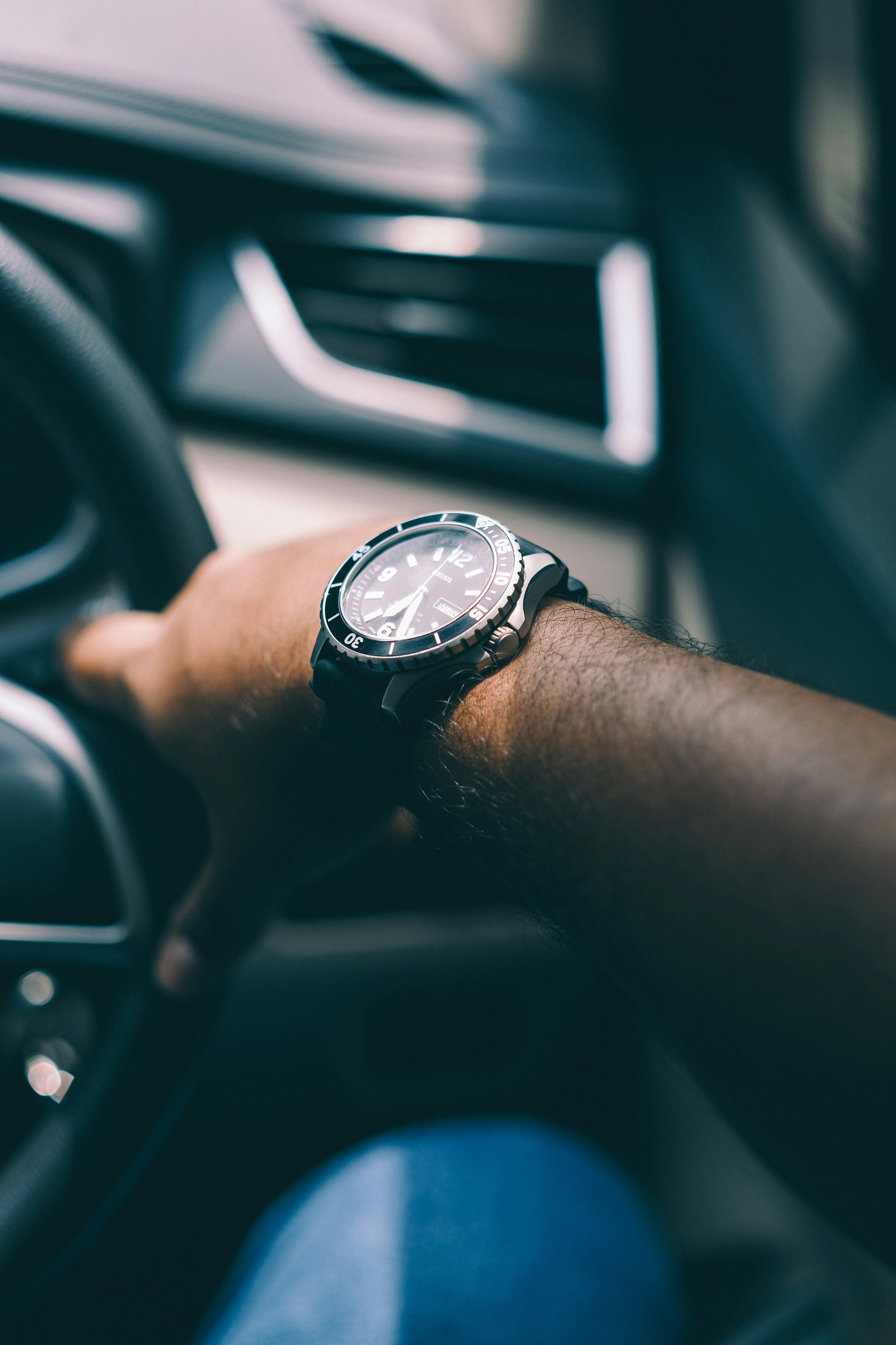 a close up of a person driving a car with a watch
