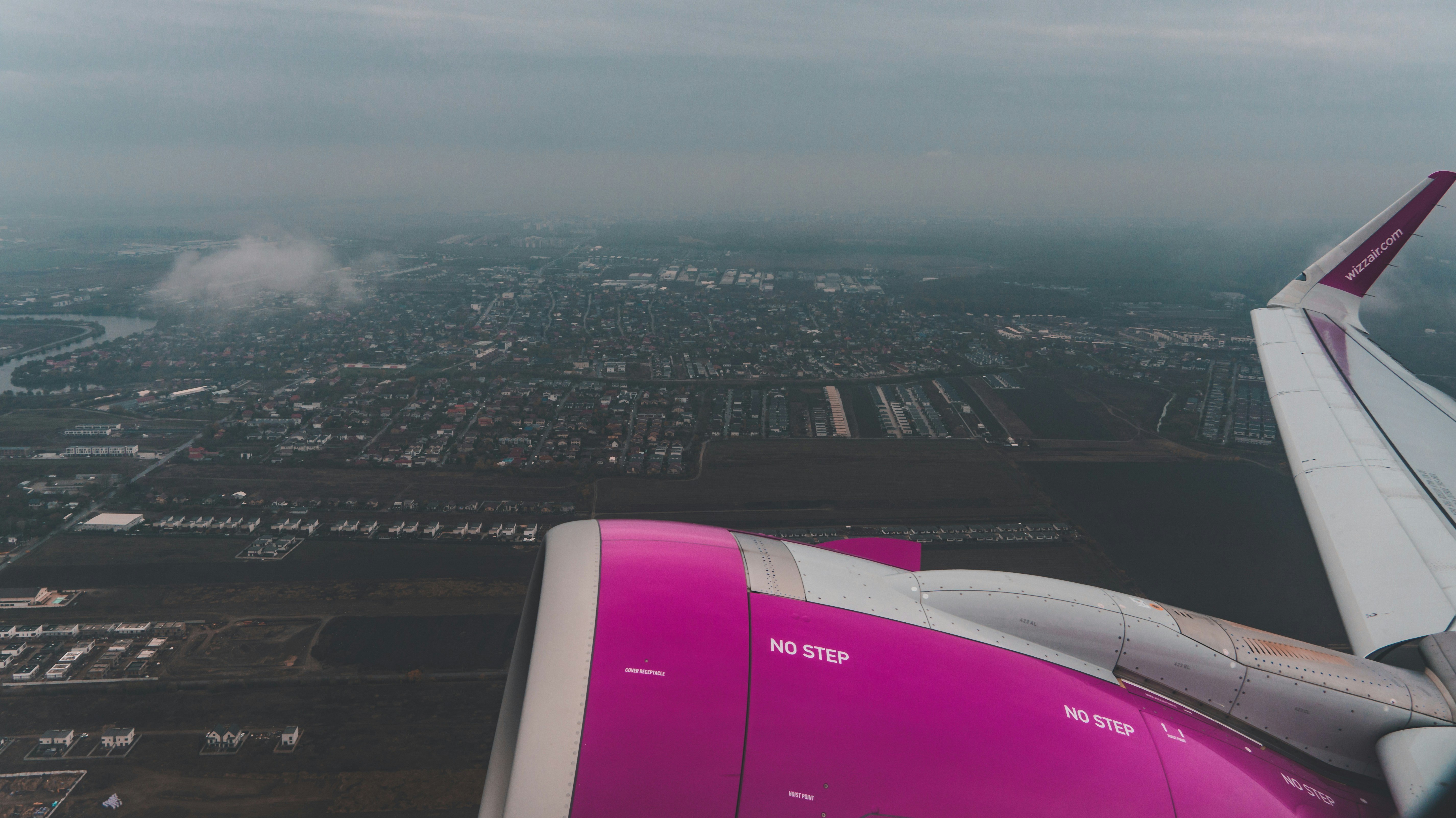 l’aile d’un avion survolant une ville