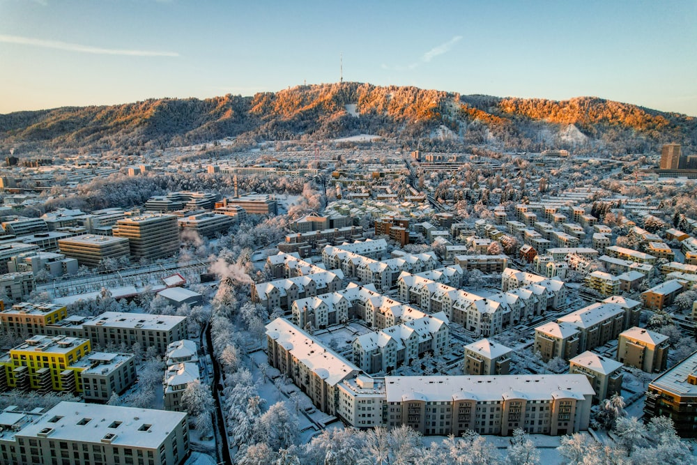 an aerial view of a city with a mountain in the background